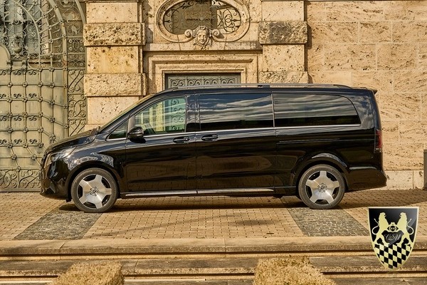 A professional chauffeur greeting passengers at an airport terminal.