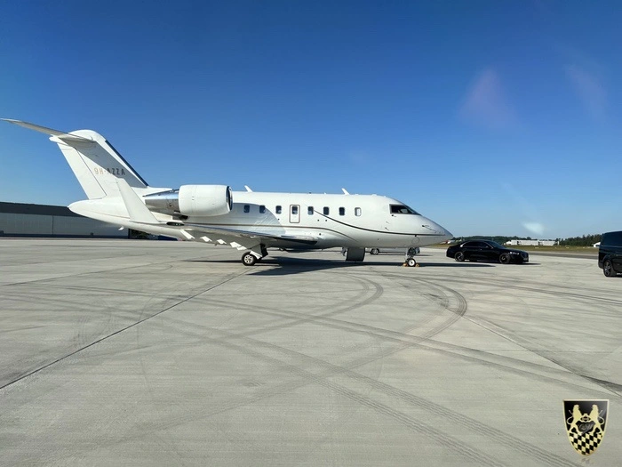A private jet ready for takeoff at an airport.