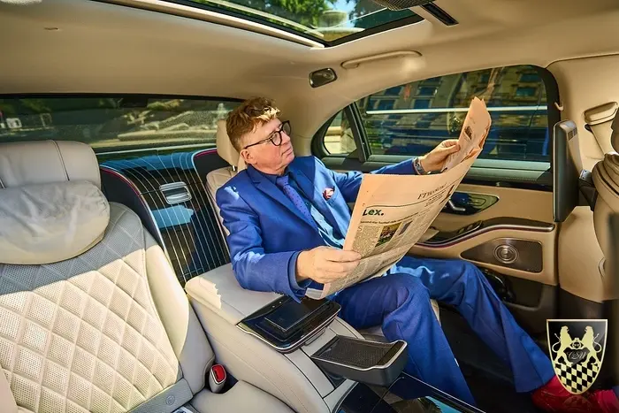 München Garmisch-Partenkirchen Transfer 2 Eine Luxuslimousine fährt auf einer malerischen Alpenstraße, umgeben von beeindruckenden Bergen und dem Panorama der Zugspitze im Hintergrund. Diese Szene vermittelt das Gefühl von Eleganz und Freiheit in der atemberaubenden Alpenlandschaft zwischen Garmisch-Partenkirchen und dem Werdenfelser Land.